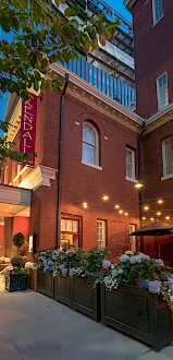 A charming brick building with outdoor seating, string lights, and a sign reading 