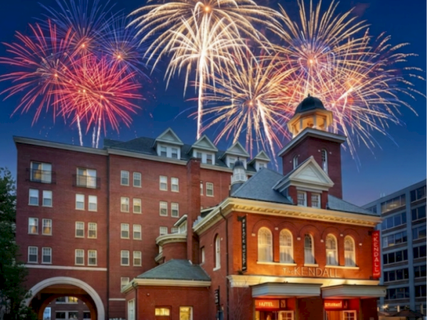 Fireworks light up the night sky above the brick Kendall Hotel building.