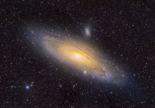 The image shows a spiral galaxy with a bright core, surrounded by numerous stars in space.