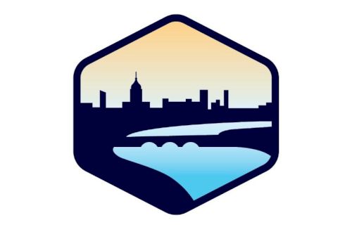 The image depicts a logo with a city skyline, river, and bridge inside a hexagonal shape against a gradient sky background.