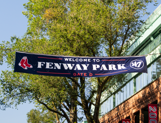 A sign reading &ldquo;Pen Yawar Park&rdquo; (likely a park entrance) with trees and a building in the background, under a sunny sky.