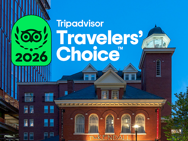 Tripadvisor Travelers&rsquo; Choice 2026 logo over a nighttime photo of The Kendall hotel, with bicycles outside and city buildings in view.